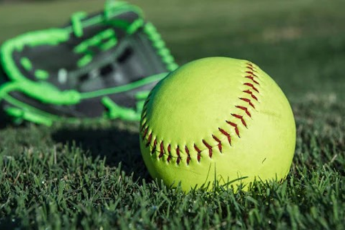 softball on grass with green glove